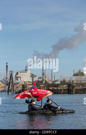 Tacoma, Washington, États-Unis. 31 octobre 2020. Un couple montre son soutien au candidat à la présidence Joe Biden tout en prenant part au Grit City Costume Paddle à Tacoma, Washington. Ils pagayent le long de la voie navigable Thea Foss en face de l'usine de gaz naturel ConocoPhillips. Crédit : Paul Christian Gordon/Alay Live News Banque D'Images