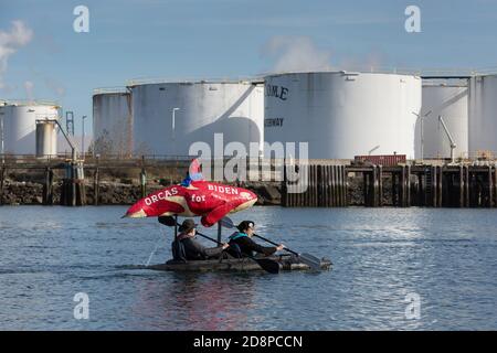 Tacoma, Washington, États-Unis. 31 octobre 2020. Un couple montre son soutien au candidat à la présidence Joe Biden tout en prenant part au Grit City Costume Paddle à Tacoma, Washington. Ils pagayent le long de la voie navigable Thea Foss en face de l'usine de gaz naturel ConocoPhillips. Crédit : Paul Christian Gordon/Alay Live News Banque D'Images