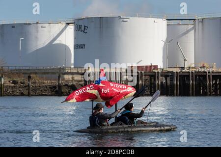 Tacoma, Washington, États-Unis. 31 octobre 2020. Un couple montre son soutien au candidat à la présidence Joe Biden tout en prenant part au Grit City Costume Paddle à Tacoma, Washington. Ils pagayent le long de la voie navigable Thea Foss en face de l'usine de gaz naturel ConocoPhillips. Crédit : Paul Christian Gordon/Alay Live News Banque D'Images