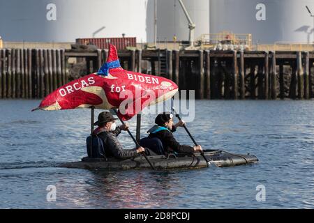 Tacoma, Washington, États-Unis. 31 octobre 2020. Un couple montre son soutien au candidat à la présidence Joe Biden tout en prenant part au Grit City Costume Paddle à Tacoma, Washington. Ils pagayent le long de la voie navigable Thea Foss en face de l'usine de gaz naturel ConocoPhillips. Crédit : Paul Christian Gordon/Alay Live News Banque D'Images