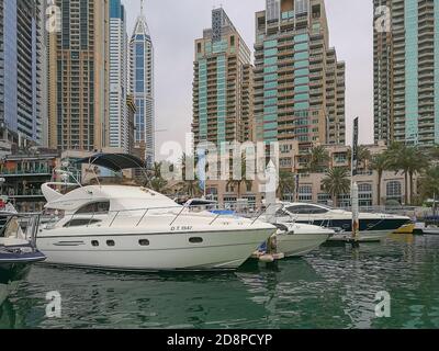 Luxueux yachts devant la marina de Dubaï gratte-ciels futuristes par temps de pluie nuageux. Vue sur la ville de Dubaï. Club de yacht de Dubaï. Banque D'Images