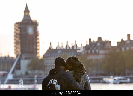 Londres, Grande-Bretagne. 31 octobre 2020. Un couple baiser par la Tamise à Londres, en Grande-Bretagne, le 31 octobre 2020. 21,915 autres personnes en Grande-Bretagne ont été testées positives pour le COVID-19, portant le nombre total de cas de coronavirus dans le pays à 1,011,660, selon les chiffres officiels publiés samedi. Credit: Han Yan/Xinhua/Alay Live News Banque D'Images