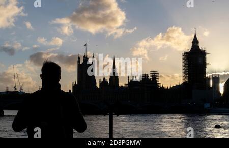 Londres, Grande-Bretagne. 31 octobre 2020. Un homme prend des photos du Palais de Westminster (chambres du Parlement) à Londres, en Grande-Bretagne, le 31 octobre 2020. Le Premier ministre britannique Boris Johnson a annoncé samedi que l'Angleterre entrera dans un confinement de jeudi d'un mois pour tenter de réprimer la résurgence du coronavirus. Credit: Han Yan/Xinhua/Alay Live News Banque D'Images