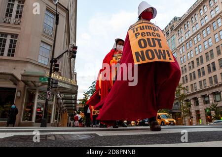 Washington, DC, Etats-Unis, 31 octobre 2020. Photo : des manifestants traversent la rue F NW lors d'une marche organisée par le centre de refus du fascisme. Pour l'événement, les femmes habillées de servantes vêtues de capes rouges du Tale de la servante ont défilé dans le centre-ville de Washington pour protester contre les politiques fascistes et les abus de l'Administration Trump, tout en exhortant les gens à descendre dans la rue pour empêcher Trump de voler l'élection ou de surmentir son mandat. La manifestation a continué de refuser la demande du fascisme de destitution immédiate de Donald Trump et de Mike Pence. Crédit : Allison C Bailey/Alay Live News Banque D'Images