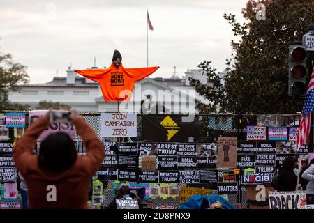 Washington, DC, Etats-Unis, 31 octobre 2020. Photo : visiteur de Black Lives Matter Plaza prenant une photo d'une figure sur un bâton au-dessus de la clôture de Lafayette Square à la Maison Blanche. La figure porte le sweat-shirt orange de refuser le fascisme, et porte le nom de leur initiative: Trump/Pence dehors maintenant! Il porte également un chapeau Black Lives Matter. La statue d'Andrew Jackson et la Maison Blanche sont visibles derrière la figure. Photographié lors d'une marche organisée par refuser le fascisme DC pour protester contre les politiques fascistes et les abus de l'Administration Trump. Crédit : Allison C Bailey/Alay Live News Banque D'Images