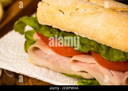 Gros plan du jambon, de la tomate et de la laitue sur une assiette sur un fond rustique. Mise au point sélective. Banque D'Images