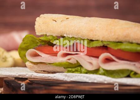 Gros plan du jambon, de la tomate et de la laitue sur une assiette sur un fond rustique. Mise au point sélective. Banque D'Images