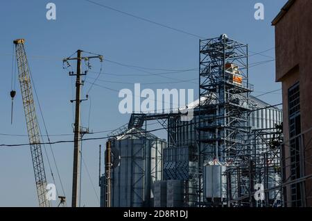 Processus de construction d'un terminal de grain moderne dans le port maritime. Silos cylindriques en métal pour la réception et le stockage de marchandises en vrac de grain. Exportation de grain. Banque D'Images