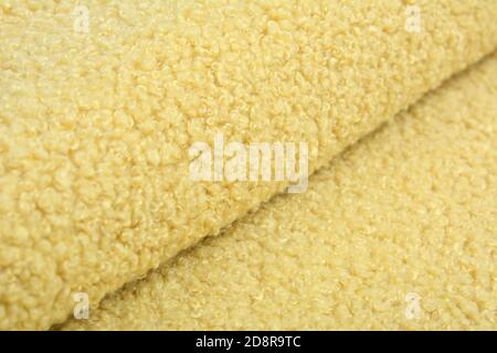 Jaune Karakul Résumé texture artificielle fourrure tissu, arrière-plan, gros plan. Toile de fond molletonnée, jouets pour enfants en fausse fourrure. Banque D'Images