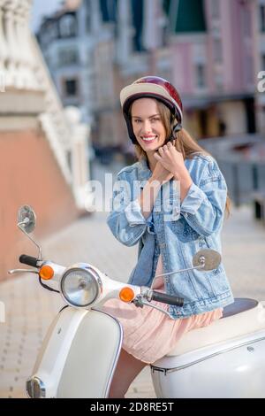 Femme portant une veste en denim et un casque rouge Banque D'Images