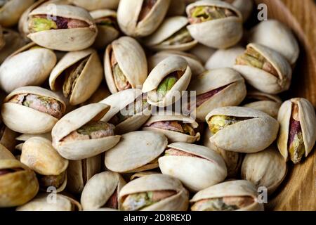 Un gros plan d'un bol de pistaches rôties saines dans leurs coquilles partiellement ouvertes. Les noix contiennent de la vitamine B6 et de la vitamine E. Banque D'Images