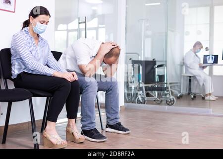 Homme et femme pleurant dans la salle d'attente de l'hôpital après de mauvaises nouvelles du médecin. Le personnel médical donne des résultats de test défavorables. Homme et femme stressés lors d'un rendez-vous médical. Banque D'Images