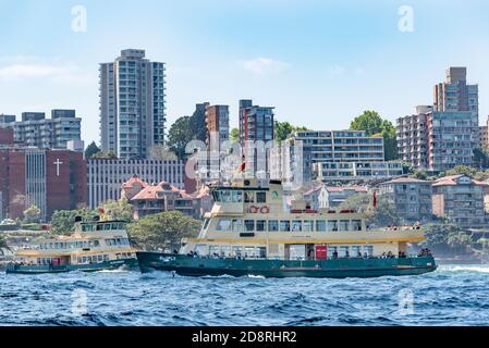 Deux traversiers de première classe de la flotte de Sydney traversent des sentiers près du Sydney Harbour Bridge à Sydney, en Australie, au cours d'un après-midi printanier ensoleillé Banque D'Images