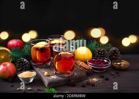 Vin rouge de Noël chaud aux épices et aux oranges sur une table rustique en bois. Boisson chaude traditionnelle pour les vacances de Noël et d'hiver. Banque D'Images