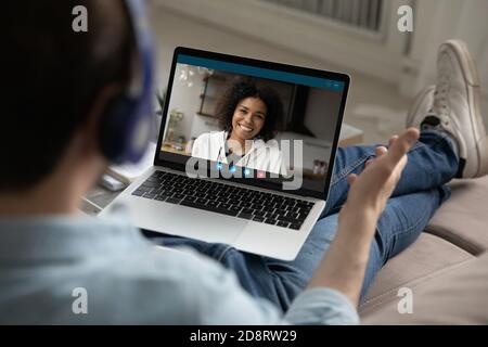 Vue arrière homme portant un casque chattant avec une femme souriante en ligne Banque D'Images