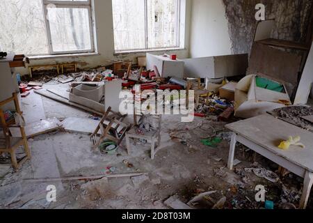 Meubles et jouets éparpillés dans un jardin d'enfants abandonné à Pripyat. Des dégâts et des ordures dans la chambre. Un bâtiment abandonné dans les réinitialiseurs de Tchernobyl Banque D'Images