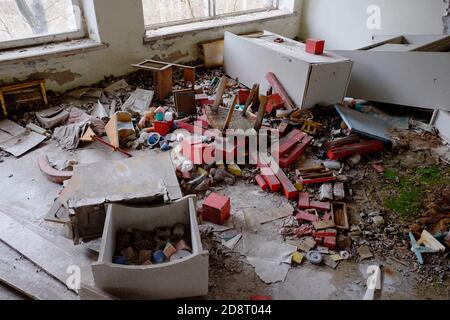 Meubles et jouets éparpillés dans un jardin d'enfants abandonné à Pripyat. Des dégâts et des ordures dans la chambre. Un bâtiment abandonné dans les réinitialiseurs de Tchernobyl Banque D'Images