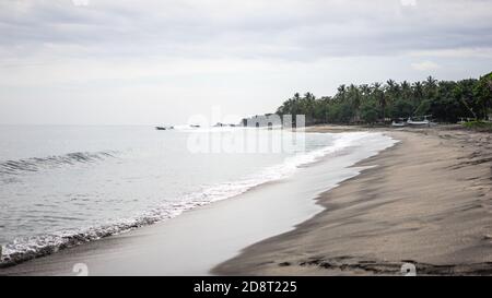 Belle plage vide le matin sur l'île de Lombok en Indonésie, plage noire en Indonésie, sable avec cendres volcaniques Banque D'Images