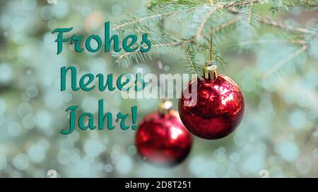 Joyeux nouvel an en allemand. Le fond flou de l'arbre de Noël est décoré de boules rouges. Bokeh. Bannière de Noël Banque D'Images