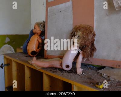 Jouets créepeux pour enfants dans une école maternelle abandonnée dans la zone d'exclusion radioactive. Vieilles poupées sales. Banque D'Images