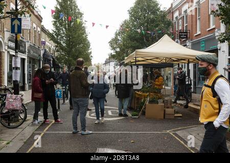 Londres, Royaume-Uni. 1er novembre 2020. Chiswick détient le deuxième marché floral avec des précautions covid. Plantes, fleurs et livres de jardinage en preuve au marché des fleurs qui se déverse dans Devonshire Road. Le conseiller Ron Mushiso est bénévole en tant que délégué dirigeant le système de voies de circulation. Masques et assainisseur disponibles à l'entrée. Crédit : Peter Hogan/Alay Live News Banque D'Images