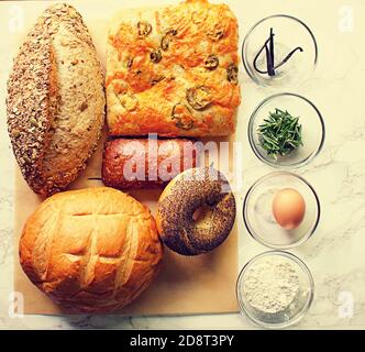 Groupe de produits de boulangerie sur papier de cuisson avec les ingrédients dans petits bols en verre Banque D'Images