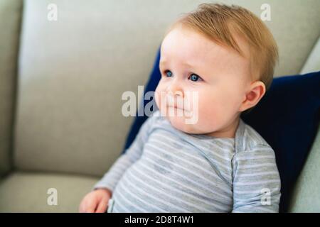 Portrait du bébé garçon assis sur le canapé. Banque D'Images