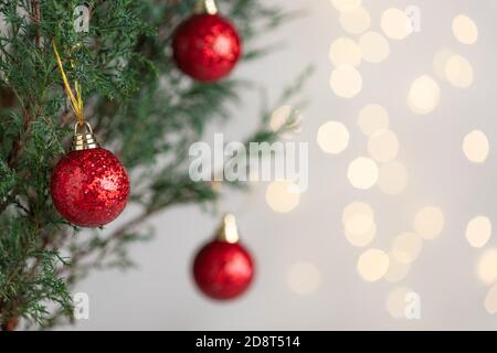 décorations de noël rouges sur l'arbre contre des lumières floues sur l'arrière-plan. Banque D'Images