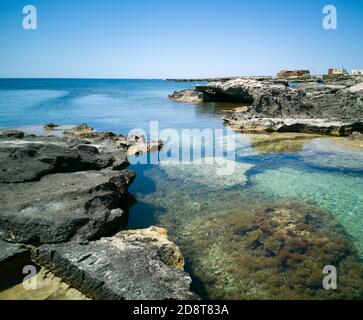 Les eaux turquoise claires et criardes de la côte rocheuse de Favignana, une des îles de l'archipel Egadi en Sicile Banque D'Images