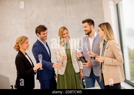 Groupe de gens d'affaires excités qui célèbrent et toaster avec du champagne au bureau Banque D'Images