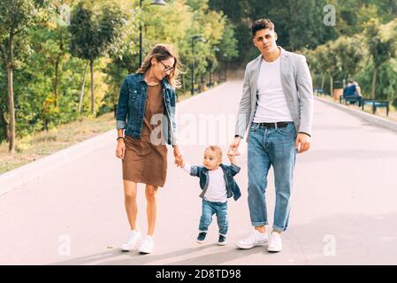 Photo dans le parc d'une famille marchant heureusement. Banque D'Images