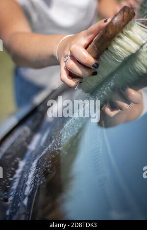 Gros plan d'une femme lavant une voiture Banque D'Images