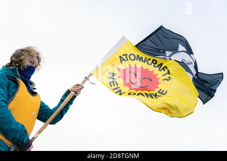 Nordenham, Allemagne. 1er novembre 2020. Un activiste de 'Stop Castor' est debout avec un drapeau avec l'inscription 'nucléaire Power? Non merci' près de l'embarcadère Union Pier à Nordenham, où le navire transportant six roulettes avec des déchets nucléaires hautement radioactifs devrait arriver. Credit: Mohssen Assanimoghaddam/dpa/Alay Live News Banque D'Images