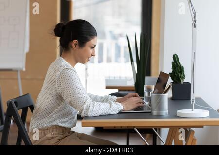 Jeune femme indienne de l'ethnie travaillant sur ordinateur. Banque D'Images