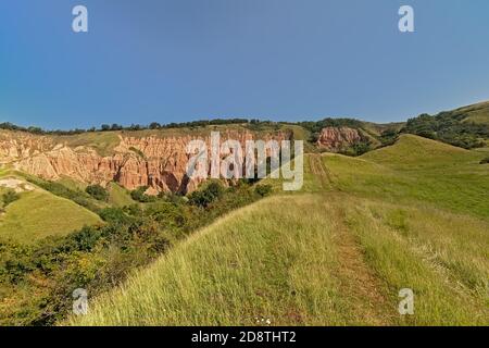 Sentier de randonnée vers les rochers de la formation géologique de Rapa Rosie, le grand canyon de Roumanie, sous un ciel bleu clair. Banque D'Images