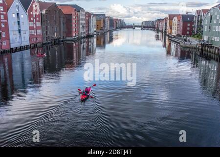 Kayakistes sur la rivière Nidelva parmi les maisons colorées au bord de la rivière à Trondheim, en Norvège Banque D'Images