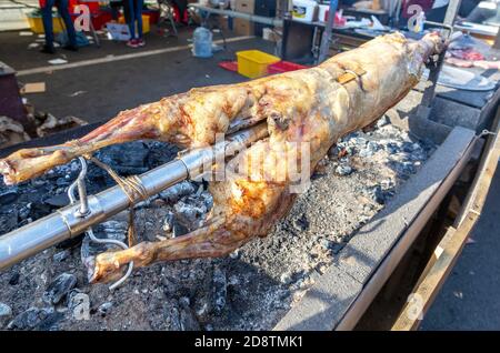 Cuisson de la carcasse d'agneau sur une broche rôtie sur le feu ouvert du barbecue dans le marché de rue. Rôti d'agneau ou de porc traditionnel serbe Banque D'Images