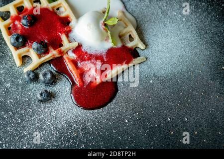 Gaufres belges classiques maison fraîches, parées de glace, de bleuets frais et de menthe, vue de dessus. Gaufres savoureuses. Concept petit déjeuner Banque D'Images