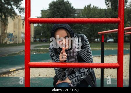 Jeune fille problèmes de socialisation nuageux jour d'automne. Belle fille regarde directement dans l'appareil photo, photo de rue, gros plan Banque D'Images