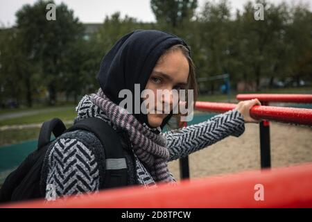 Jeune fille problèmes de socialisation nuageux jour d'automne. Belle fille regarde directement dans l'appareil photo, photo de rue, gros plan Banque D'Images