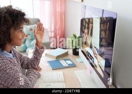 Fille africaine discutant avec un professeur à distance sur l'apprentissage par appel vidéo sur ordinateur. Banque D'Images