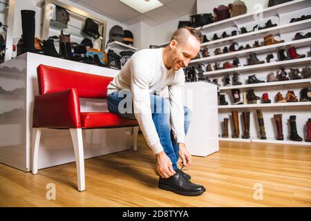 Un homme recherche de nouvelles chaussures dans le magasin de chaussures Banque D'Images