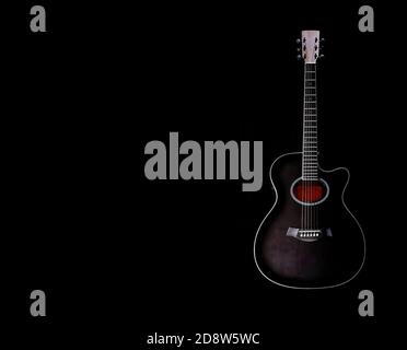 guitare acoustique noire subtilement éclairée avec l'intérieur en rouge sur fond noir , espace de copie Banque D'Images
