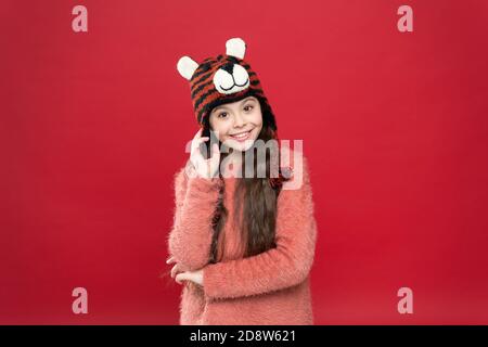 joyeux enfant dans des vêtements chauds d'hiver en tricot et chapeau à rabats prêt pour les activités de vacances, mode d'hiver. Banque D'Images