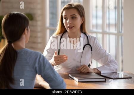 Jeune femme rendant visite à un médecin attentif au centre médical moderne Banque D'Images