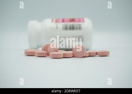 Médicaments pharmaceutiques pilules de vitamines déversées d'une bouteille, sur fond gris. Copier l'espace pour le texte. Banque D'Images