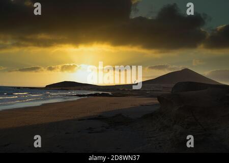 Coucher de soleil sur la plage de Medano à Tenerife avec un homme qui fait planche à voile Banque D'Images