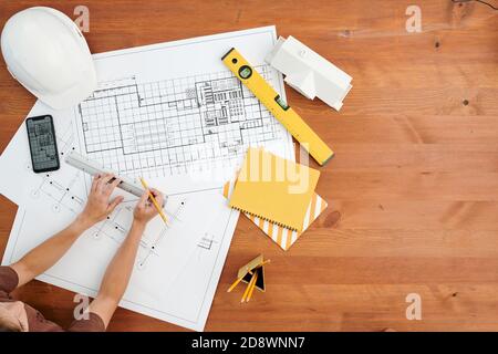 Vue de dessus des mains d'une femme moderne ingénieur ou architecte esquisse de mise en plan Banque D'Images