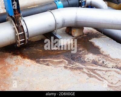 Fuite du tuyau d'eau d'égout. Fuite épaisse de déchets biologiques provenant de tuyaux en fer chromé cassés. Système d'assainissement révolutionnaire. L'eau coule sur la route depuis la rosée Banque D'Images