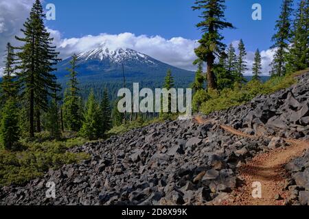 Le Pacific Coast Trail, qui serpente à travers les champs de lave du sud de l'Oregon, offre une vue splendide sur le mont McLoughlin, recouvert de neige et de nuages Banque D'Images